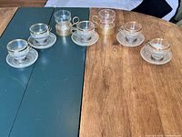 Overview of six cups in holders, six saucers, two spare holders