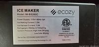 Specification label detailing model, power, refrigerant and certifications