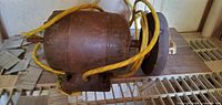 Side view of electric motor with attached grinding wheel and yellow cord