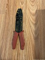 Overall view of the wire crimper/cutter/stripper showing steel head, gauge markings, red handles