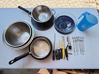 All cookware, bowls, pans, colander, pitcher, utensils overview