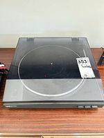 Turntable with dust cover closed on wooden surface