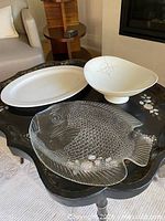Three pieces of serveware: oval white platter, clear glass fish platter, white footed Hallcraft bowl