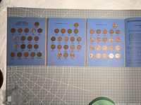 Album fully opened showing four panels of mounted cents