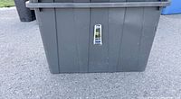 Front view of gray plastic tote showing size, color and exterior condition