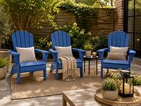 Three blue Adirondack chairs with cushions staged on patio
