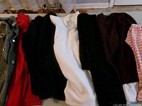 Stack of seven sweaters showing colours and textures