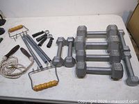 Entire lot laid out: dumbbells, chest expander, hand grips, jump rope
