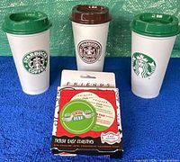 Front view of three Starbucks tumblers and boxed Friends coaster set