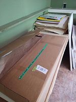 Box and stack of canvas panels, sketchpads and loose sheets