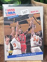 Front of sleeved 1993 Upper Deck Michael Jordan NBA Playoffs Highlights card showing action photo and caption