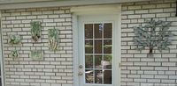 Full view of all wall art pieces mounted on brick exterior