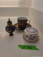 Porcelain cup & saucer, cobalt gilt ginger jar, trinket box base on countertop
