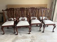 All eight matching carved mahogany chairs displayed together