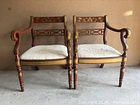 Front view of both matching gilt decorated armchairs