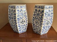 Two blue and white ceramic garden stands side by side on wood surface