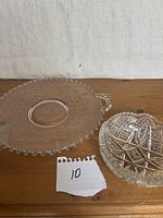 Round bead-edge glass plate and oval cut glass bowl on tabletop