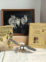 Group shot of framed art, two books and eagle figurine