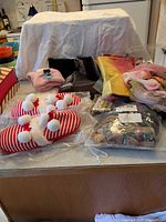 Overview of lot showing slippers, pink plush socks, zip pouches, scarves, knit bag