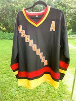 Full front view of jersey showing diagonal lettering and striping