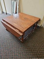table with one leaf down showing square shape and turned legs