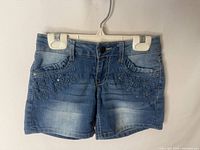 Front view of denim shorts showing embroidery, rhinestones and distressing