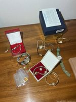 Group shot showing all wristwatches, Seiko box, spare links, earring