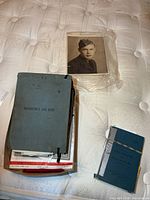 Group view showing both log books, portrait photo and stack of documents