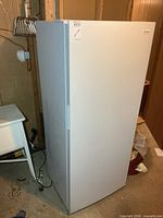 Front left perspective of Frigidaire upright freezer showing full height and side panel