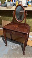 Full view of wood vanity showing drawers, legs and mirror