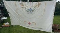 Full view of bedspread hanging outdoors showing overall design and fringe