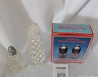 Boxed Las Vegas shakers next to two vintage crystal shakers