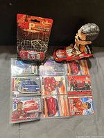 Group shot showing bobblehead, sealed die-cast car, and nine trading cards