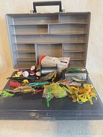 Open Flambeau tackle box displaying assorted lures, bobbers, line and soft plastics