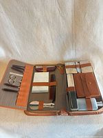 Open case showing all grooming tools, containers and brushes secured inside