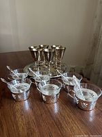 entire set arranged on table showing goblets, cups in holders, spoons, tray