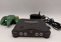 Console with controller and power adapter, frontal angled view