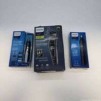 Front view of three Philips boxed grooming devices
