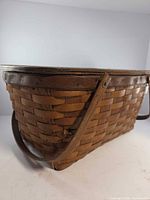 Side view showing woven splint pattern, fold-down handle and overall shape