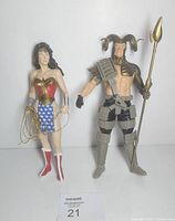 Front view of both figures standing side by side showing accessories