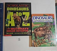 Front covers of both damaged dinosaur books