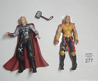 Two Thor action figures and hammer accessory with lot card