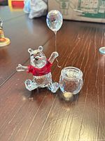 Front view of crystal Winnie the Pooh figurine with balloon and honey pot