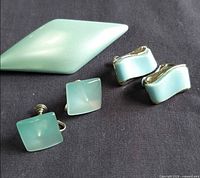 All pieces together: brooch, square screw-back earrings, curved clip-on earrings