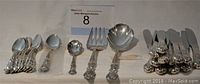 Full overview of the silverware set including knives, spoons, forks, and serving pieces arranged in groups showing pattern and quantity.