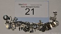 Photo showing silver-tone charm bracelet with about 29 various detailed charms representing Canadian landmarks and symbols, laid flat for full view.