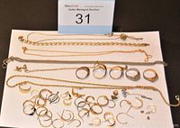 Contents of lot: necklaces, men’s rings and pierced earrings displayed