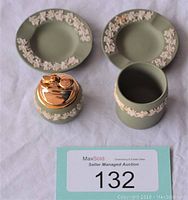 Green Wedgwood cigarette holder, lighter with gold top, and two matching ashtrays shown on white background with auction lot number card.