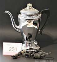 Photo showing the entire vintage Hotpoint coffee percolator with attached power cord against a black background, including the MaxSold lot number 254.