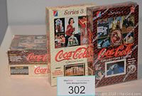 Four sealed boxes of Coca-Cola Collector Cards from Series 1 through Series 4, showing vintage Coca-Cola branding and card images on the packaging.